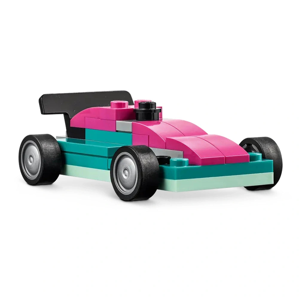 Colorful LEGO® car model in pink, teal, and black, featuring a sleek design and large black wheels, positioned on a white background.