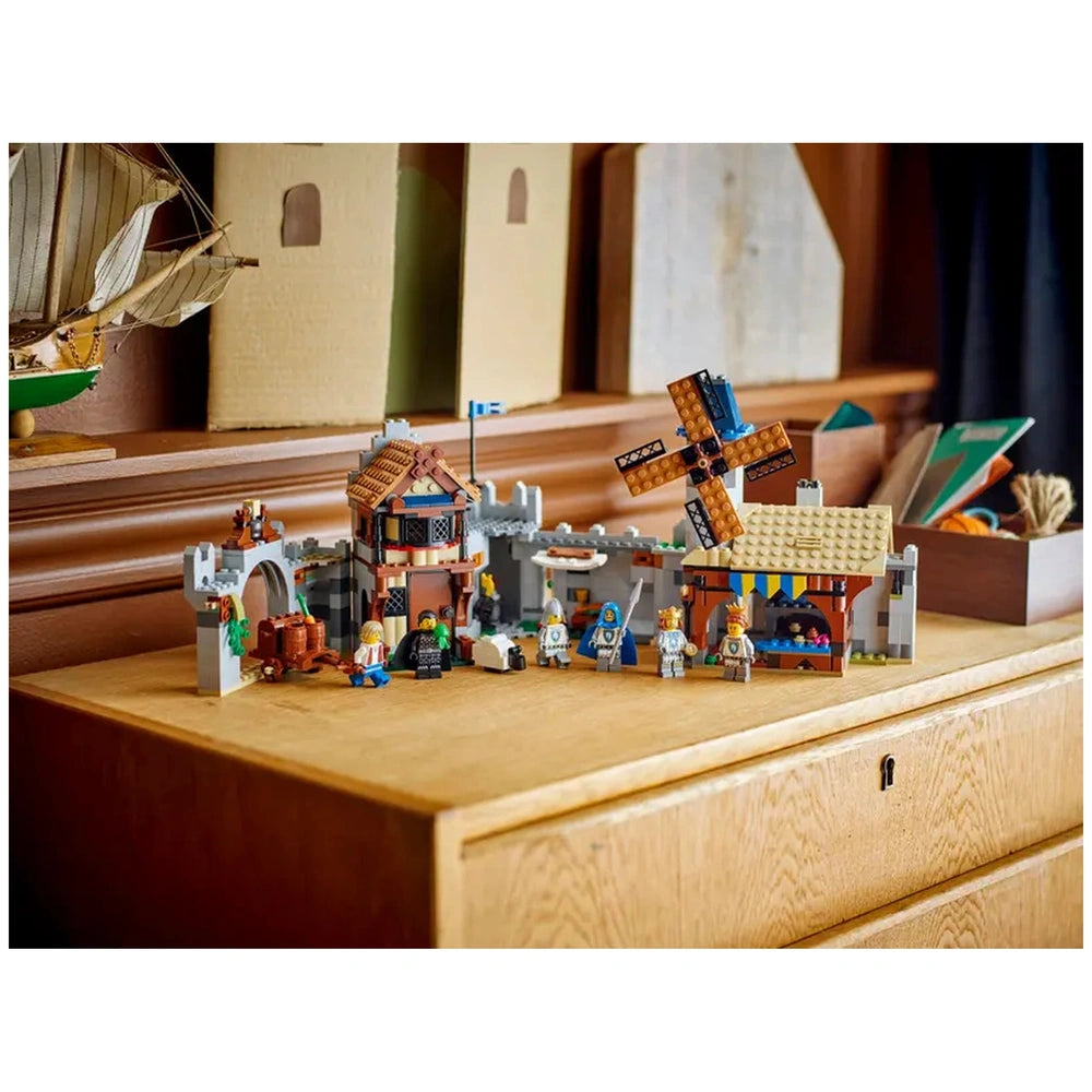 Colorful LEGO Creator 3in1 Medieval Horse Knight Castle set featuring knights, a windmill, and medieval structures on a wooden surface.