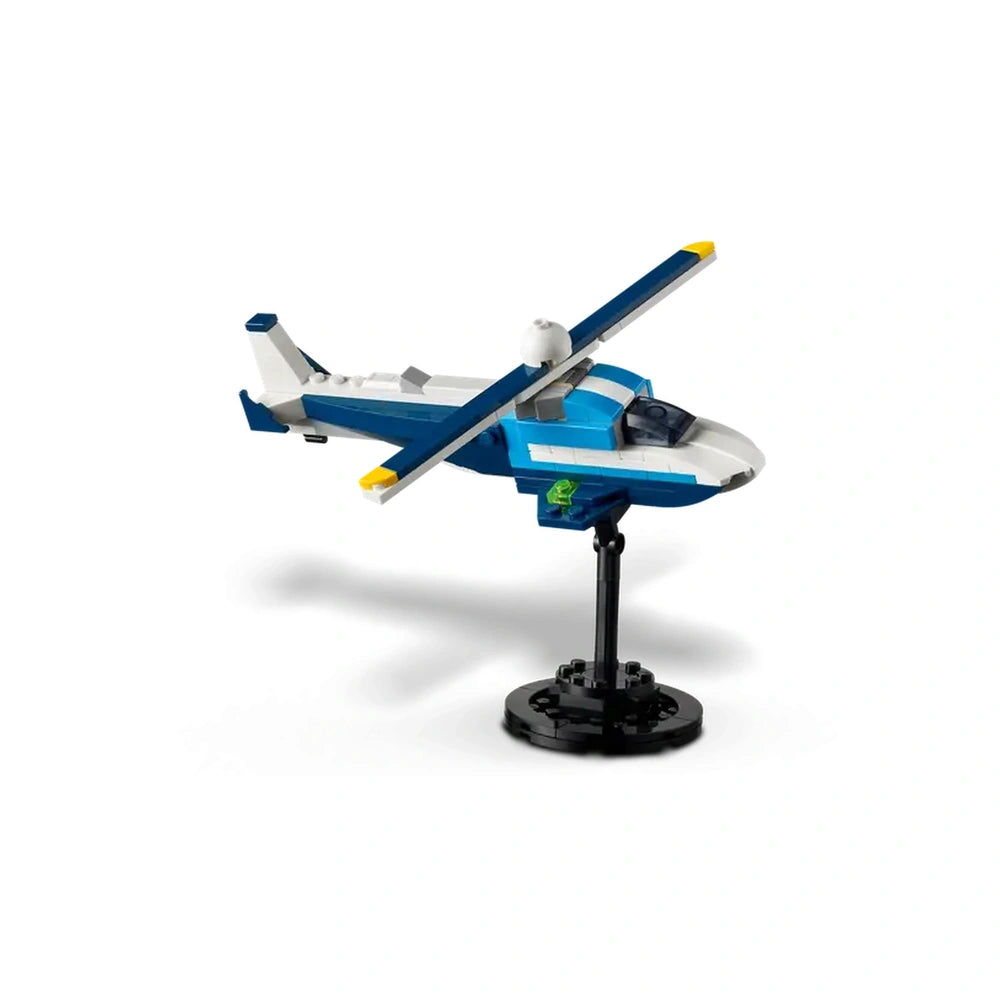 Blue and white LEGO® Creator Race Plane model displayed on a black stand, featuring a rotating propeller and sleek design.