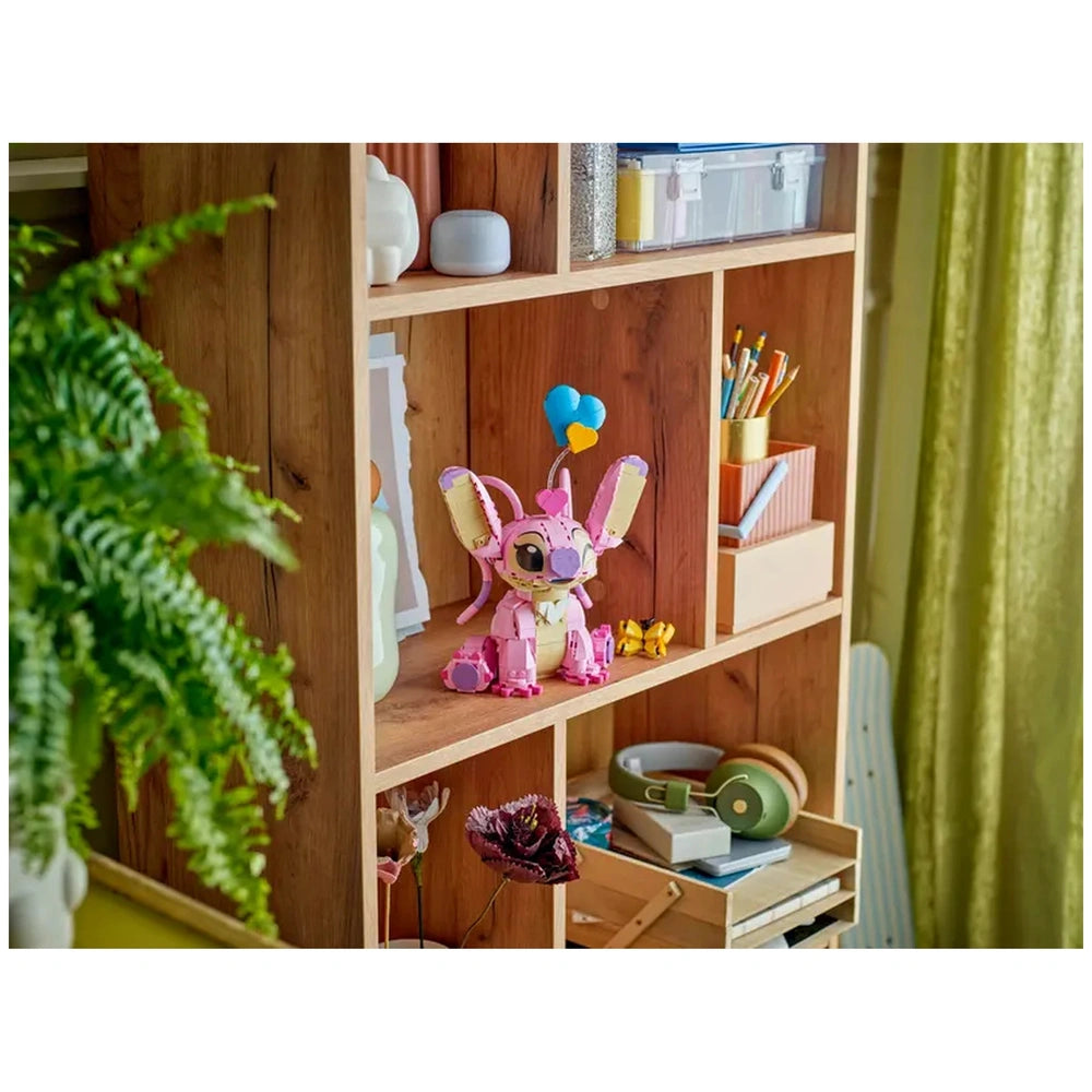 LEGO Angel building toy in pink, showcasing movable ears and a heart balloon, displayed on a wooden shelf with colorful decor.