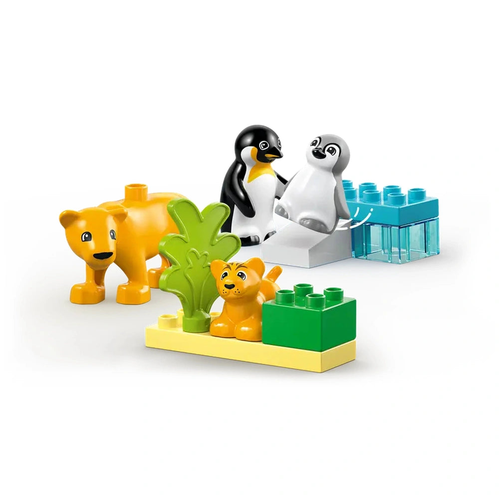 Set of LEGO® DUPLO® Wild Animal Families including two playful lions, two penguins, and colorful building blocks surrounded by greenery.