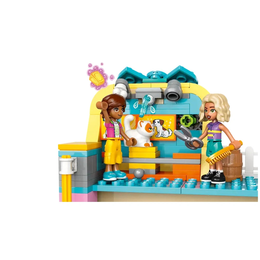 Two minidolls, one with a pet cat and the other holding scissors, stand in a colorful pet accessories shop with interactive grooming features and accessories.