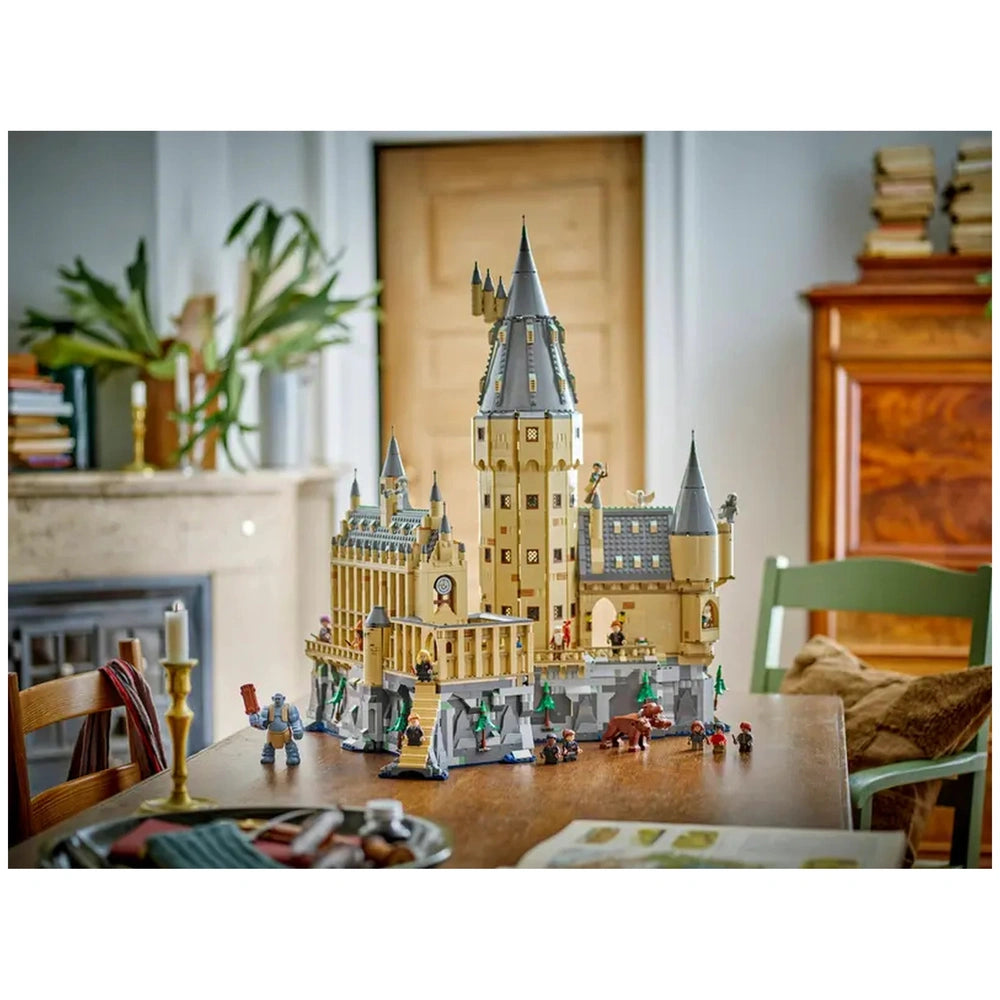 LEGO Harry Potter Hogwarts Castle set displayed on a wooden table, featuring intricate towers, minifigures, and detailed surroundings.