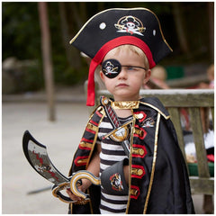 Liontouch pirate eye patch worn by a child in a pirate costume, holding a toy sword, set in a playful lifestyle scene.