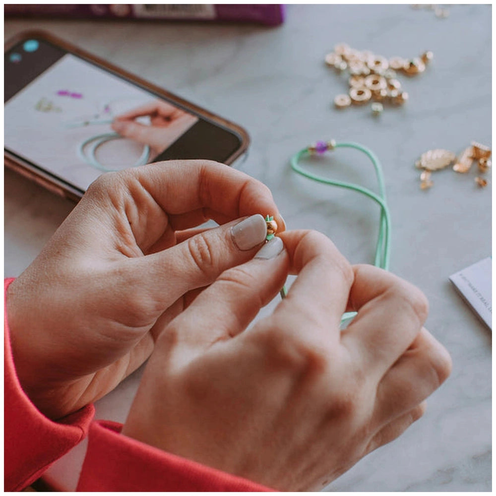 Gold Link Suede Bracelets worn by a person in a red jacket, holding a smartphone on a marble countertop.