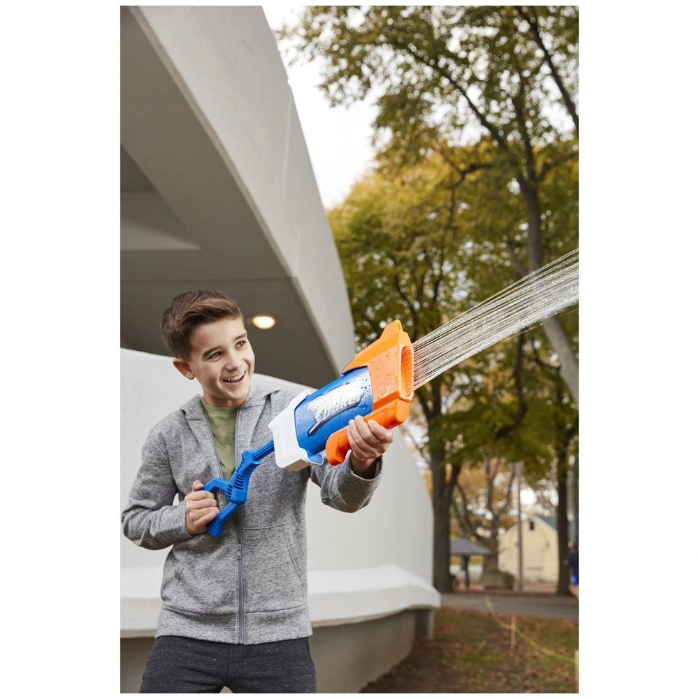 Nerf Super Soaker Rainstorm water gun in orange and blue held by a smiling boy in a gray jacket, surrounded by trees and fall