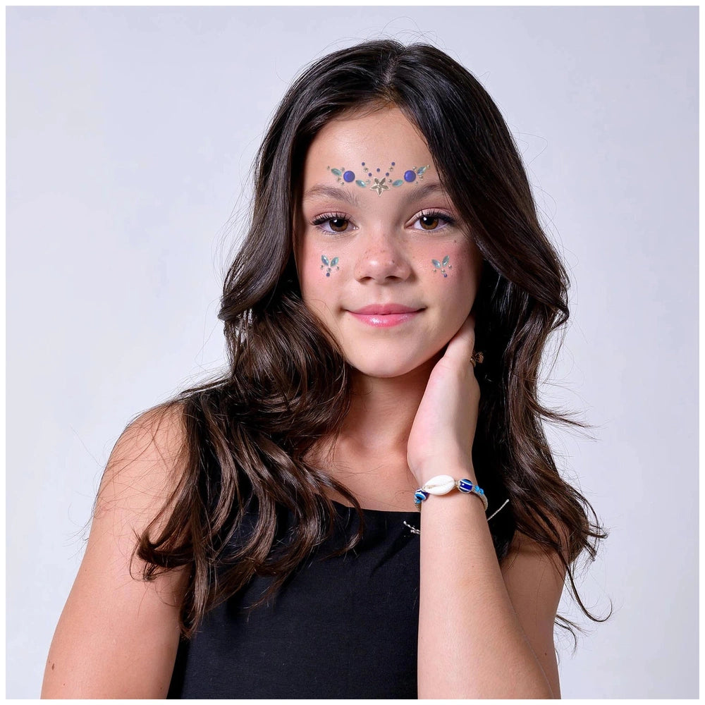 Creative star face gems pack showcased on a girl with dark hair, blue eyeshadow, pink lips, and a smile.