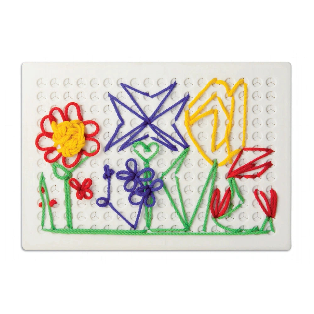 Quercetti Filo Filo arts and crafts featuring colorful yarn flowers and leaves on a textured white grid surface.