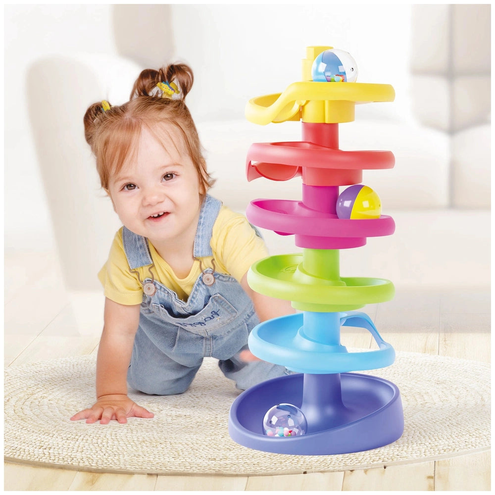 Quercetti Spiral Tower baby activity toy with multi-colored tiers and blue base, held by a child in yellow top and blue overa