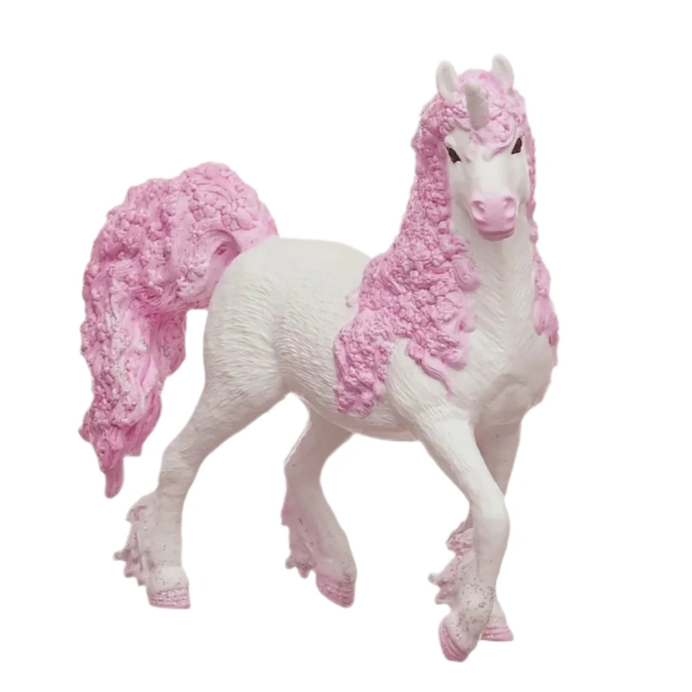 Unicorn figurine with a glossy white body and prominent pink mane and tail, standing on all fours with its head turned.
