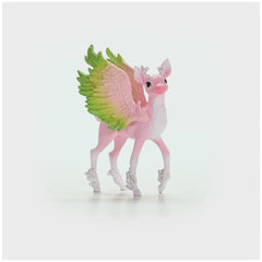 Magical fawn figurine with pink body, green wings, and antlers, standing on a white surface against a light background.