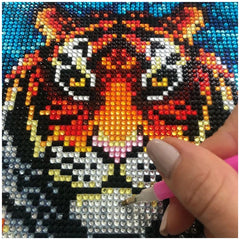 Diamond Canvas Tiger design being enhanced with a pink pen on glossy textile, showcasing vibrant colors and intricate details