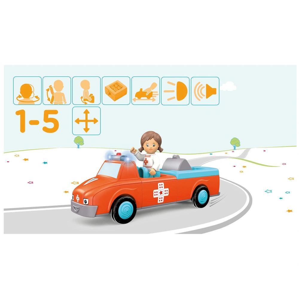 A young girl with brown hair sits in a vibrant orange toy fire truck with blue wheels, set against a simple landscape.