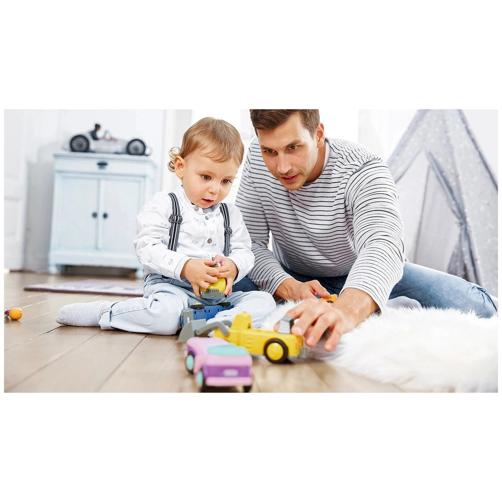 Siku - Betty Blinky construction set toys are being played with by a man and a child on a light-colored carpet.