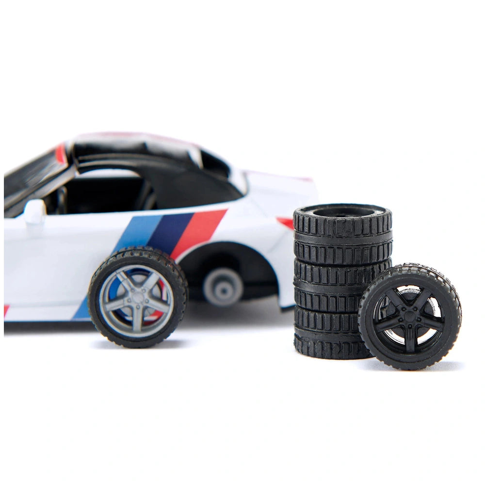 Siku BMW Z4 M40i model car in white with a red, white, and blue stripe, accompanied by two black rubber tires.