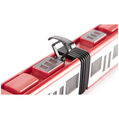 Red Bombardier tram toy with a white roof and black wheels, displayed on a smooth white surface.