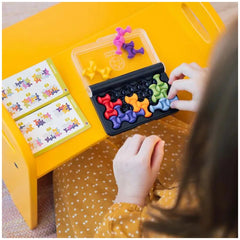 Smart Games IQ Waves logic puzzle set with colorful magnetic shapes being sorted by a child at a yellow table.