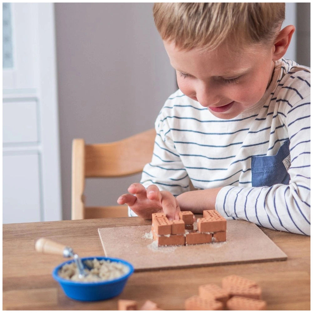 Teifoc castle building blocks set is being used by a young child engaged in creative play at a wooden table.