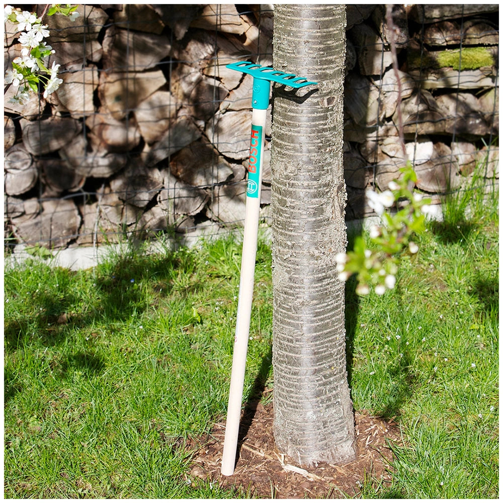 Theo Klein Bosch Garden Gardener Set with green-handled tool, wooden and metal fences, and tree with green leaves and white f
