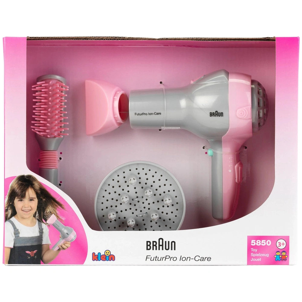Theo Klein Braun hairdryer with diffuser and brush in pink packaging featuring a transparent window and cardboard base.